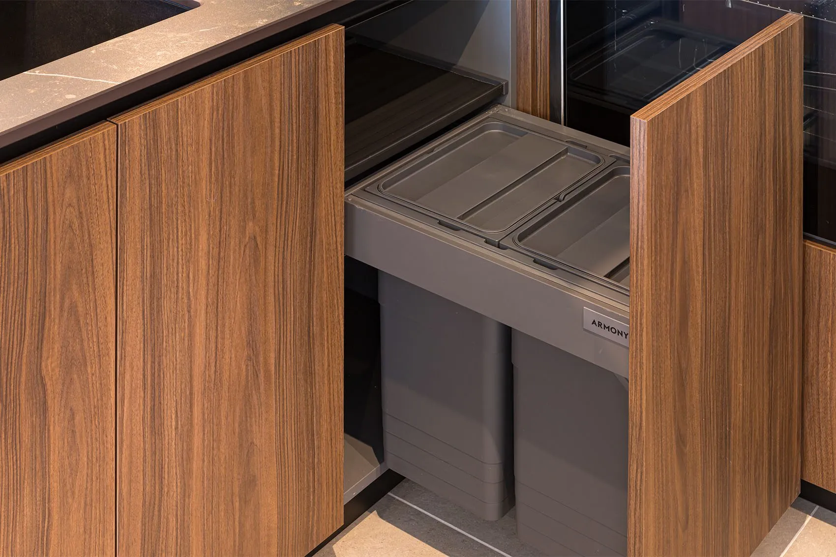 Poubelle de tri coulissante cachée derrière une façade en bois, rangement intégré à la cuisine des quais de Saône