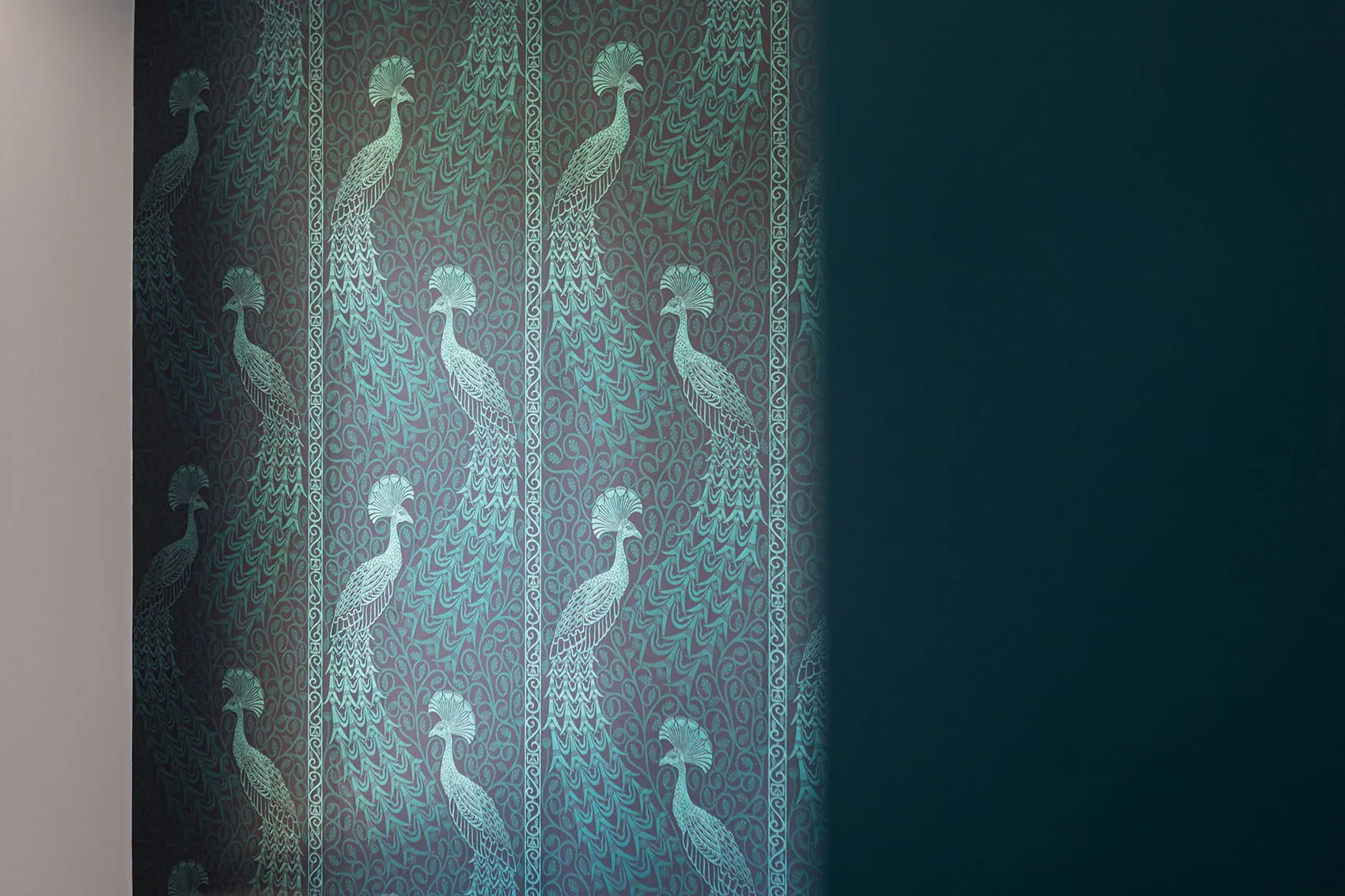 Papier peint bleu nuit à motifs de paons, détail de la décoration d’intérieur de l’appartement Gillet