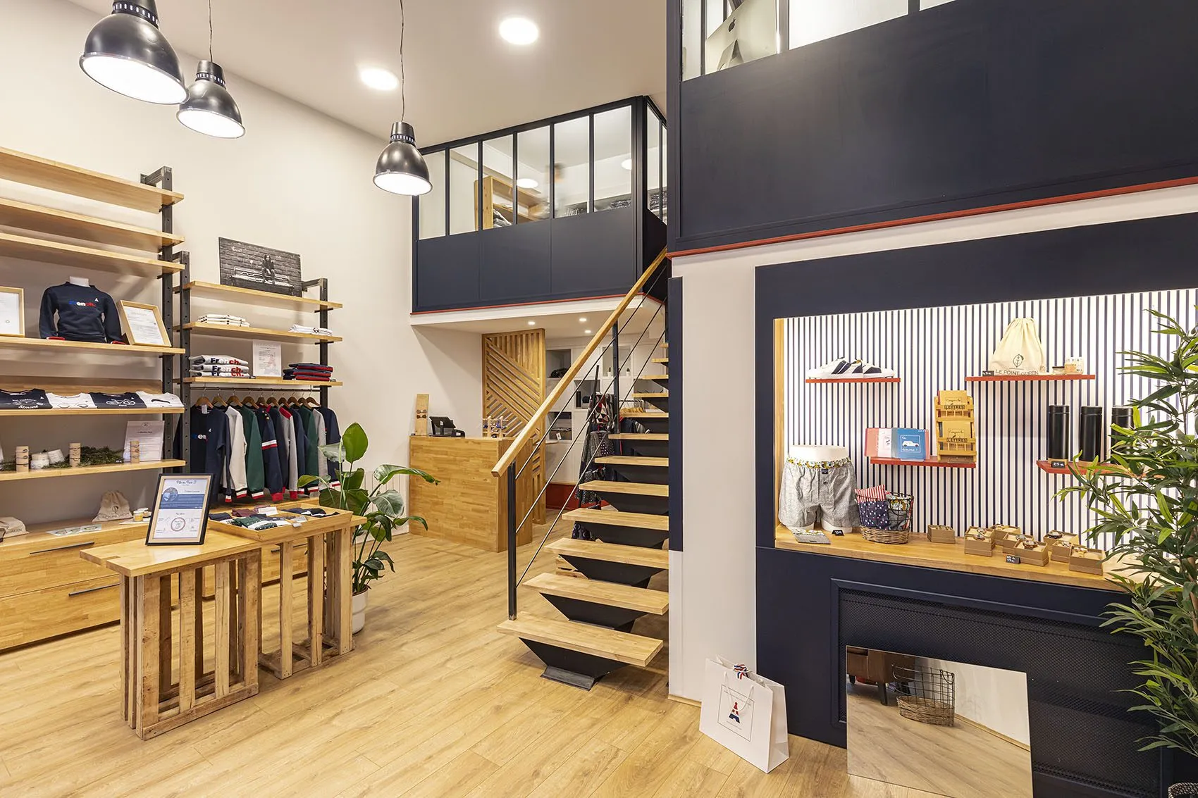 Boutique Maison FT : présentoirs en bois, escalier et mezzanine vitrée
