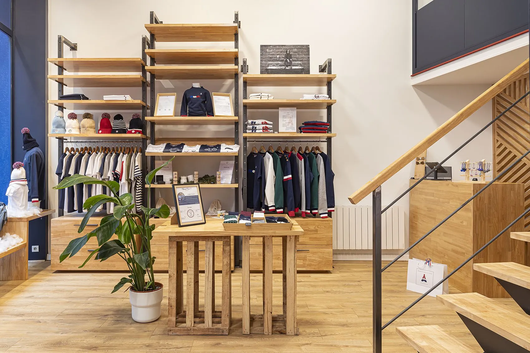 Espace de vente de la boutique Maison FT, portants et étagères le long des murs