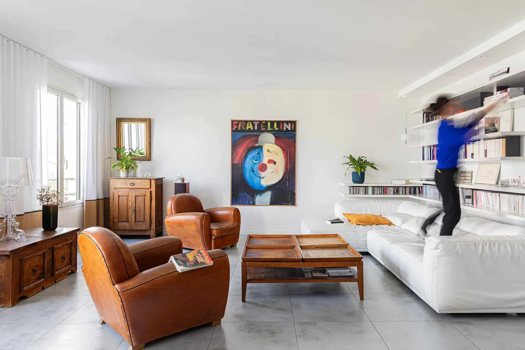 Séjour de l’appartement familial de 150 m² boulevard de la Croix-Rousse : bibliothèque blanche, canapé blanc et fauteuils club