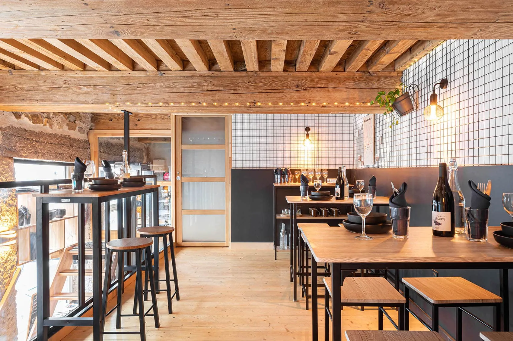 Salle du restaurant Le Dérobé, tables hautes et banquette le long du mur