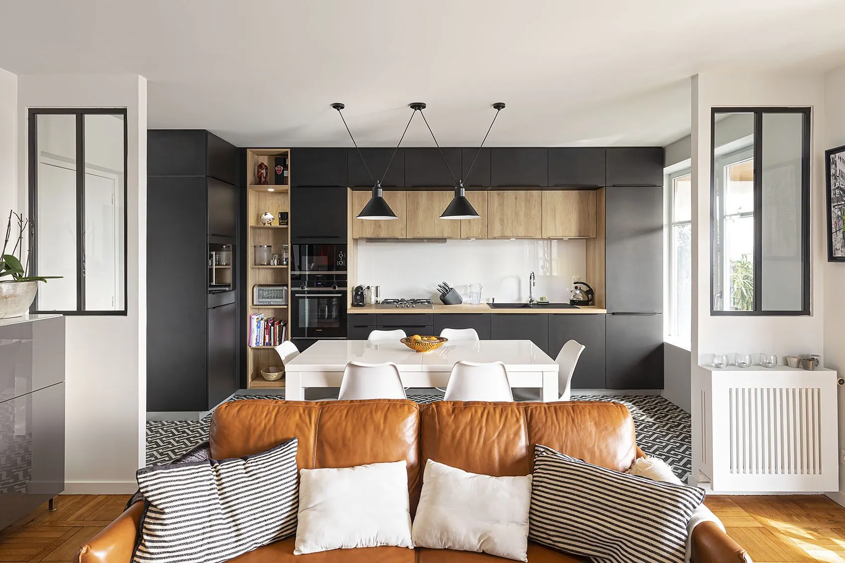 Appartement rénové rue Deleuvre à Lyon, cuisine noire et bois ouverte sur le salon