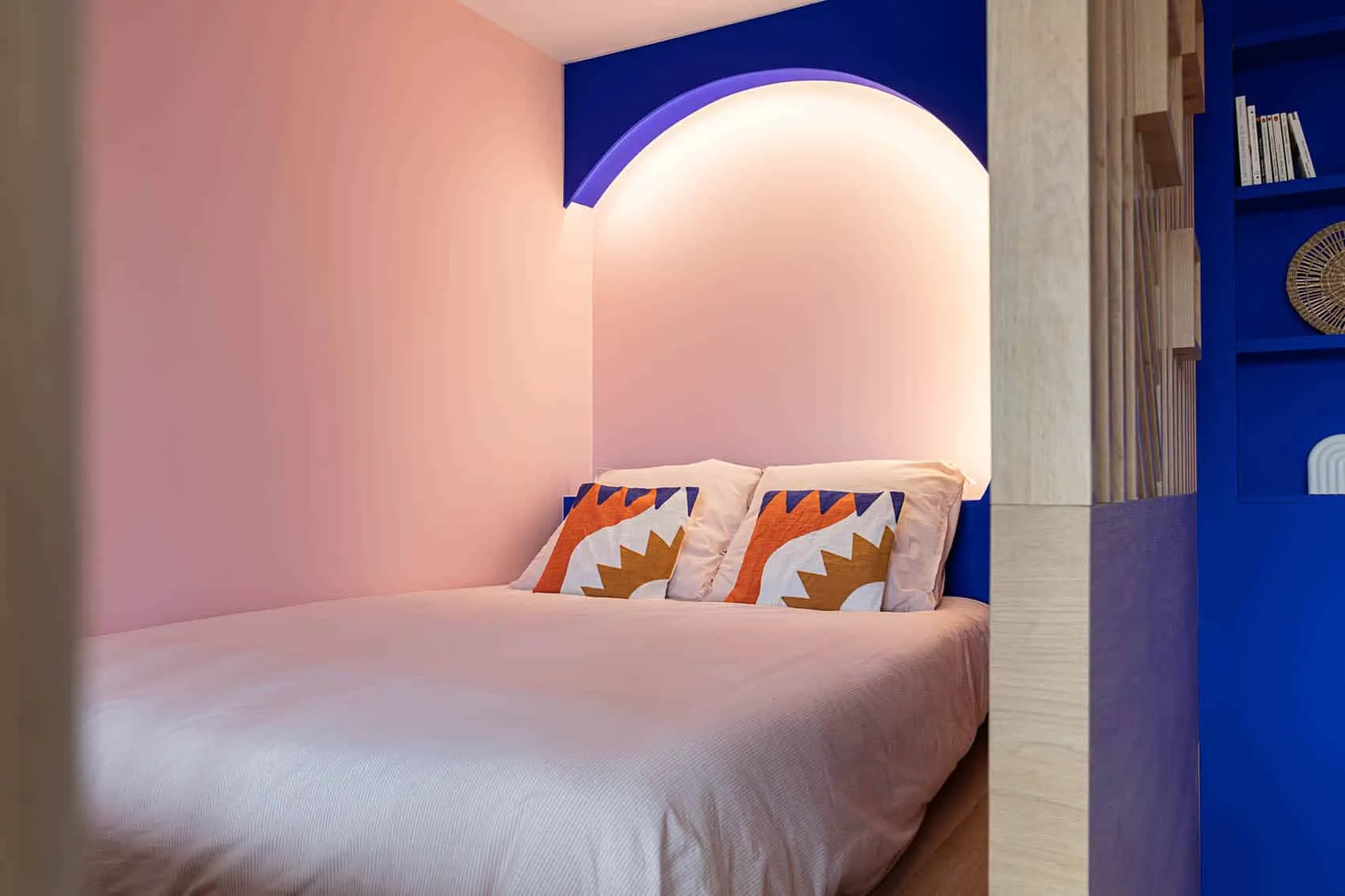Coin nuit rose poudré et bleu Klein avec tête de lit ronde éclairée, studio VEFA personnalisé