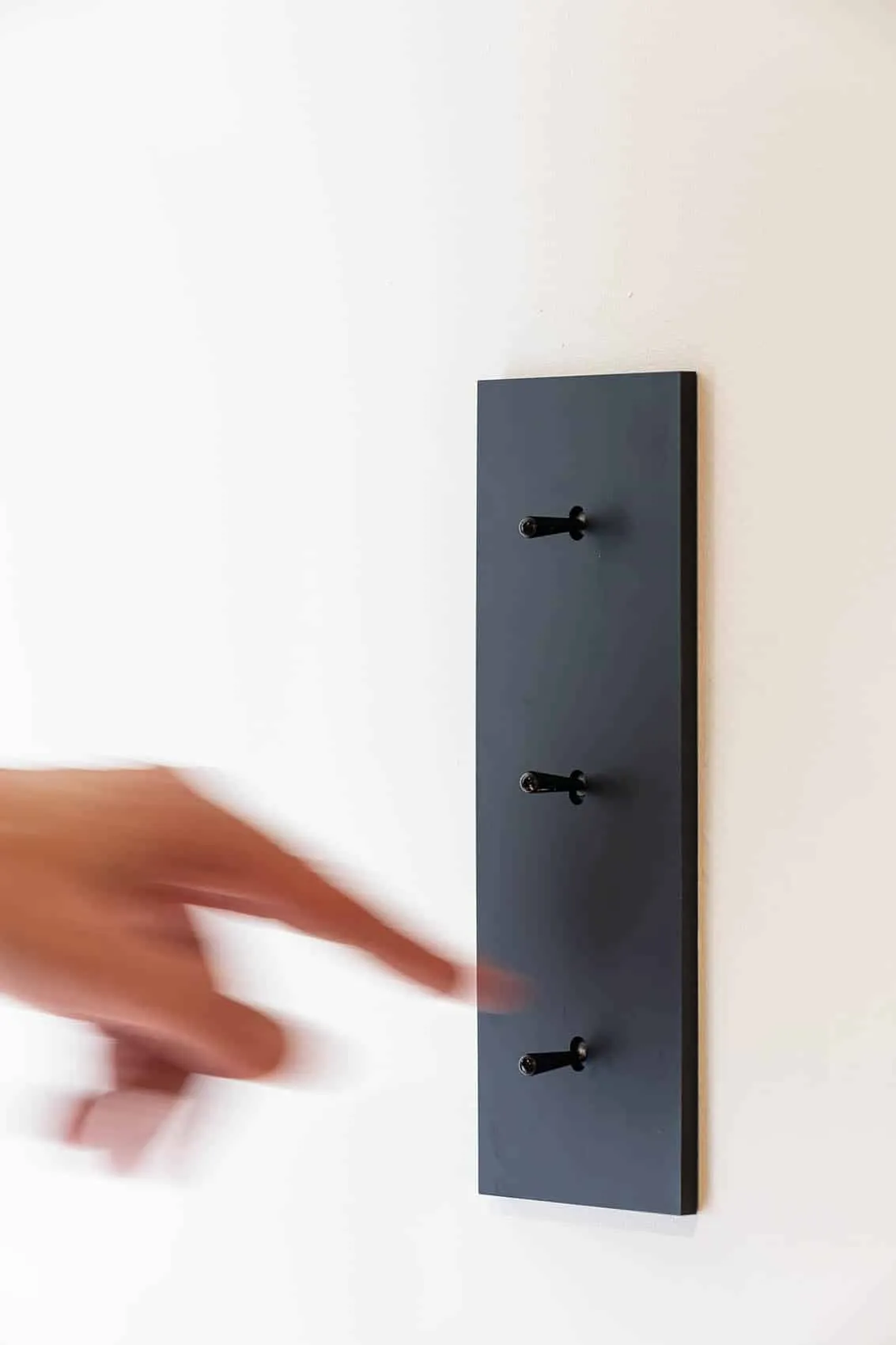 Interrupteurs noirs sur platine verticale, détail de la rénovation électrique