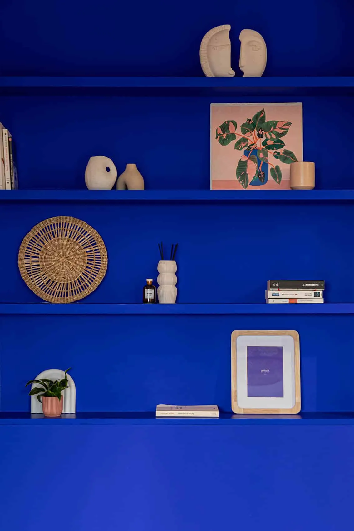 Niche bleu Klein avec étagères et objets décoratifs dans un studio neuf