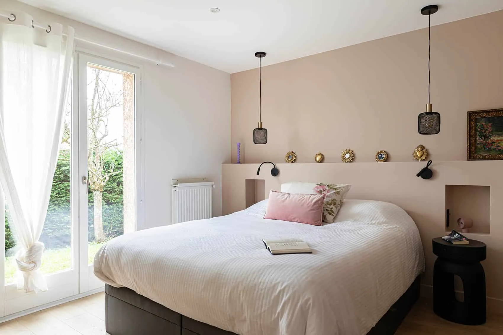 Chambre parentale aux murs rose poudré et tête de lit maçonnée à niches, rénovation d'une maison des années 80 par un architecte d'intérieur à Lyon