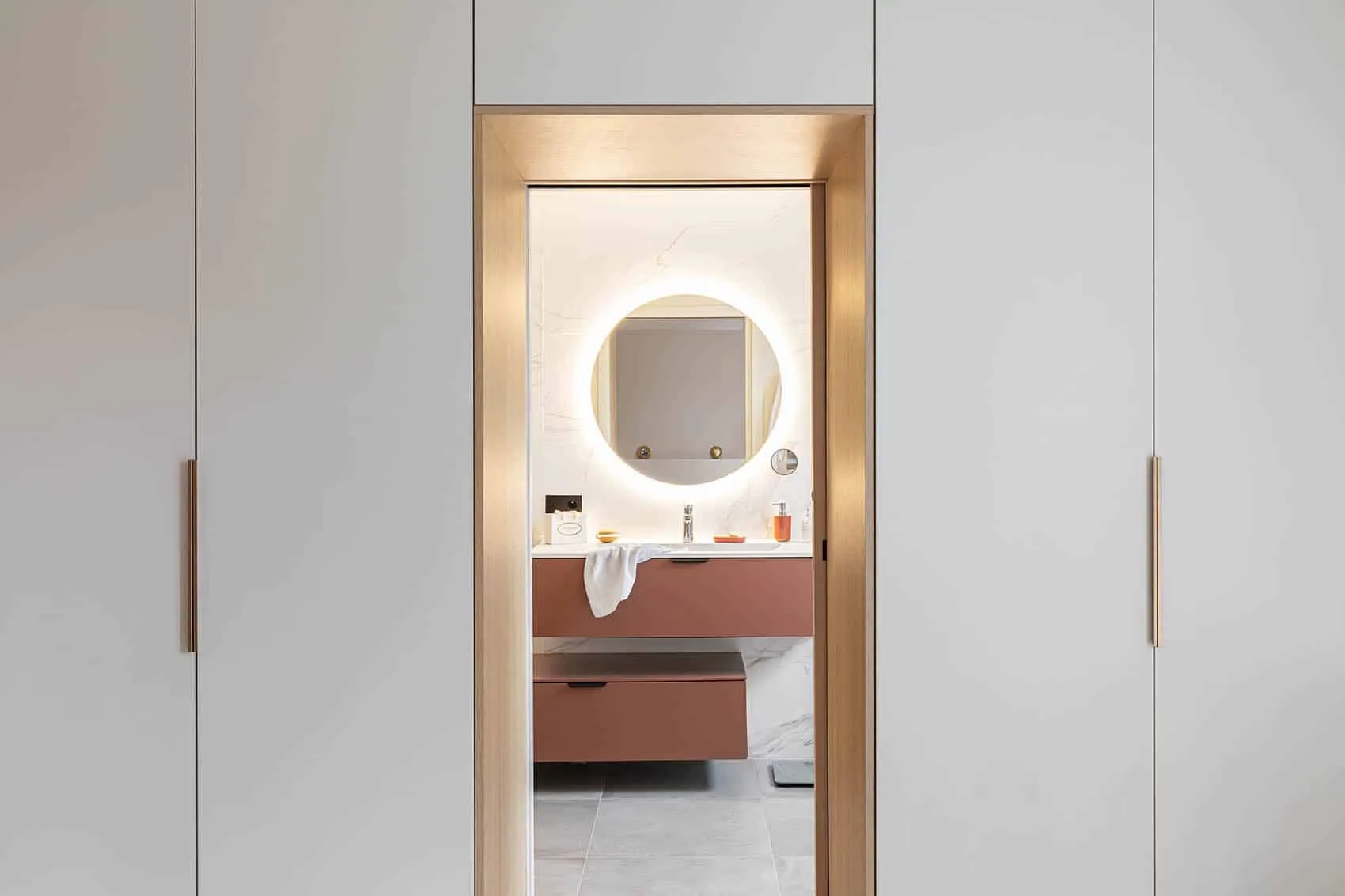 Porte ouverte sur la salle d'eau depuis le dressing, encadrement en bois
