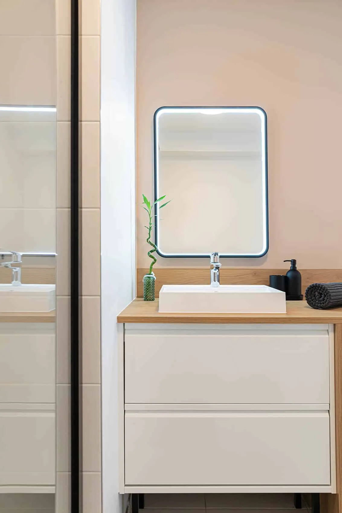 Meuble vasque blanc et miroir éclairé dans la salle d’eau