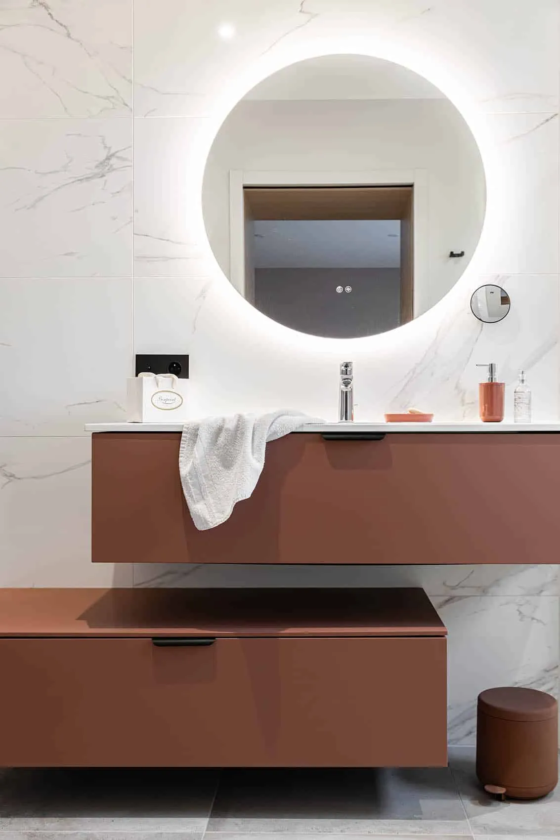 Salle de bains parentale effet marbre blanc, meuble vasque terracotta et miroir rond lumineux
