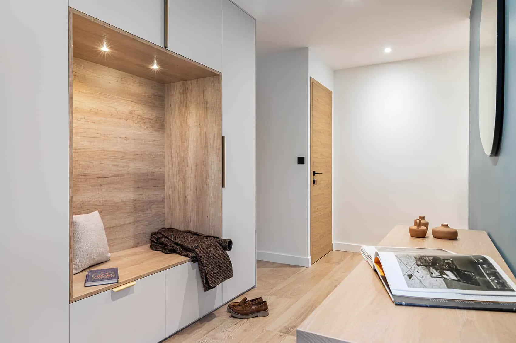 Entrée aménagée avec banc en bois, rangements toute hauteur et éclairage intégré, architecte d'intérieur à Lyon