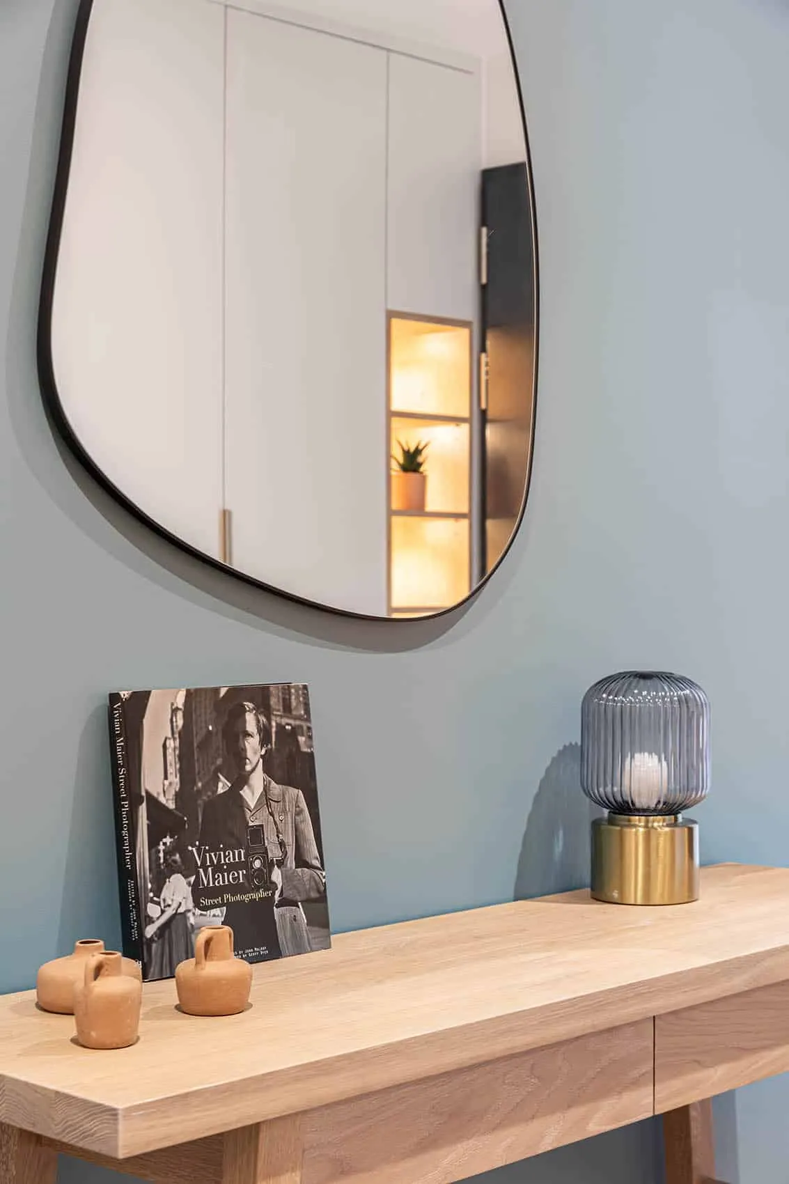 Console en bois, miroir organique et lampe à poser, décoration de l'entrée