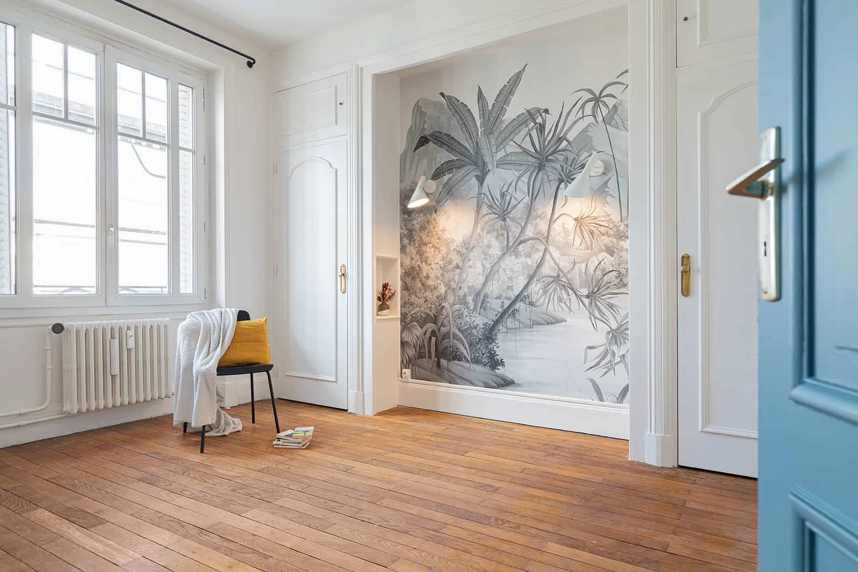 Chambre parentale au papier peint jungle noir et blanc, parquet et radiateur ancien sous la fenêtre