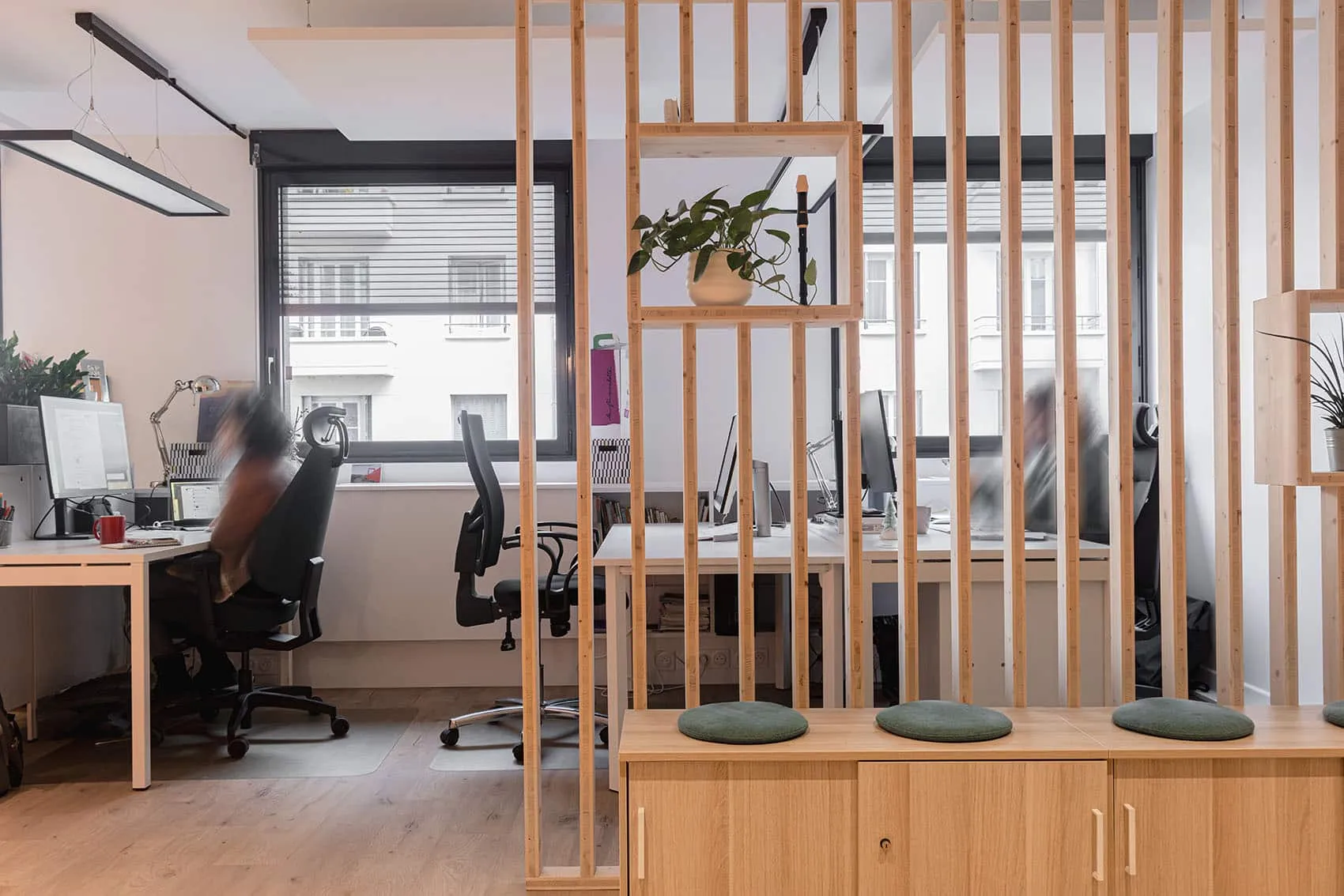 Cloison amovible à claire-voie en pin naturel séparant deux espaces de travail ouverts avec postes informatiques et rangements bois – bureaux Cap'Com à Lyon par Picture Design