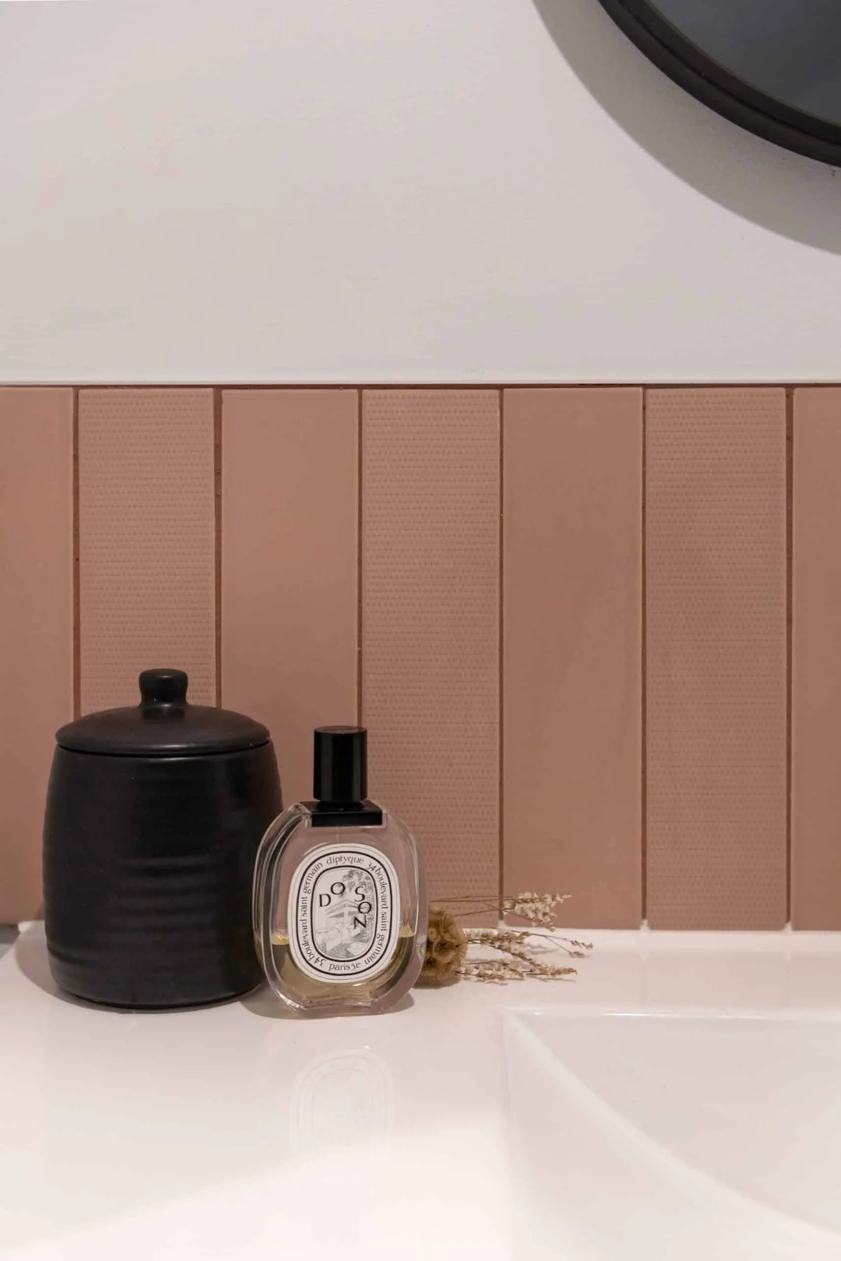 Crédence en faïence vieux rose posée à la verticale et objets de toilette sur la vasque de la salle d’eau