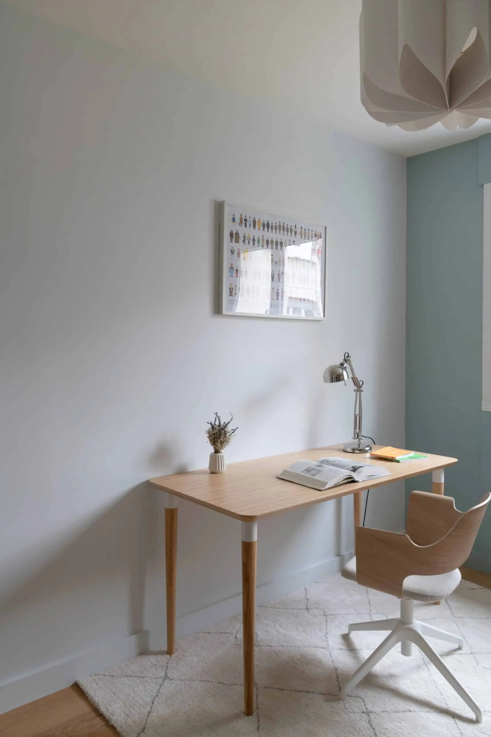 Coin bureau en bois clair avec lampe d’architecte chromée et affiche encadrée, chambre de l’appartement Bugeaud