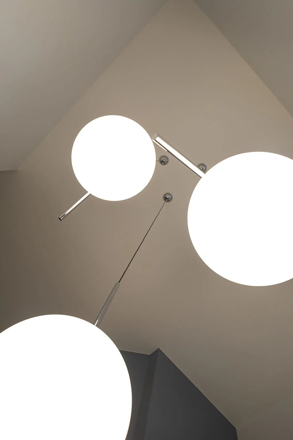 Suspensions IC Light chromées à globes blancs de Flos sous les cinq mètres de plafond de la cage d’escalier