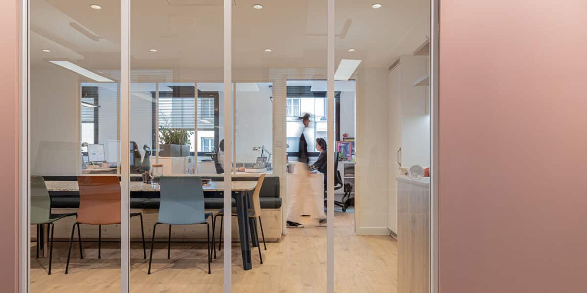 Espace de bureaux contemporain conçu par l'agence d'architecture intérieure Picture Design à Lyon, avec cloisons vitrées, mobilier sur mesure et aménagement chaleureux favorisant la collaboration.